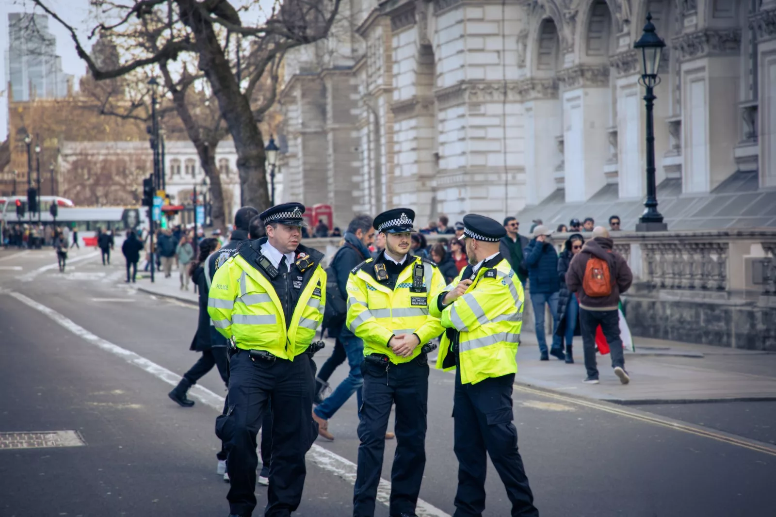 Policjanci patrolujący ruchliwą ulicę w Londynie, symbol bezpieczeństwa miejskiego i publicznego.