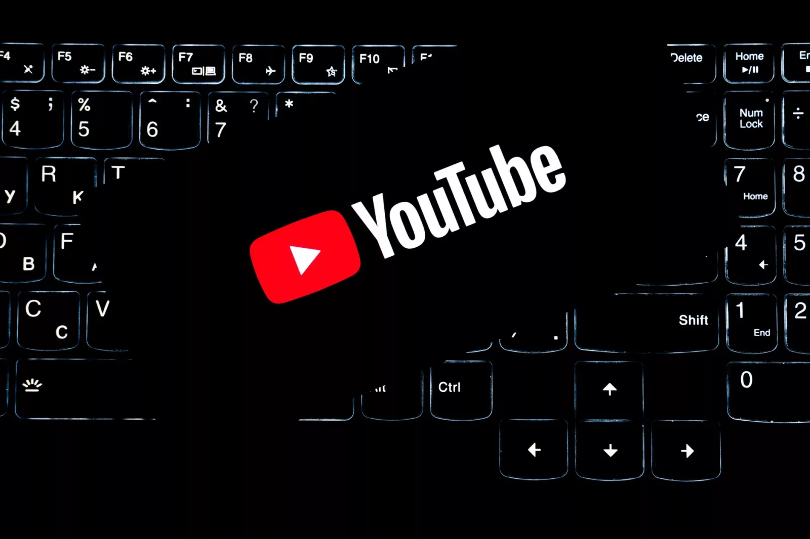 Logo YouTube wyświetlane na podświetlanej klawiaturze, symbolizujące media cyfrowe i tworzenie treści online.